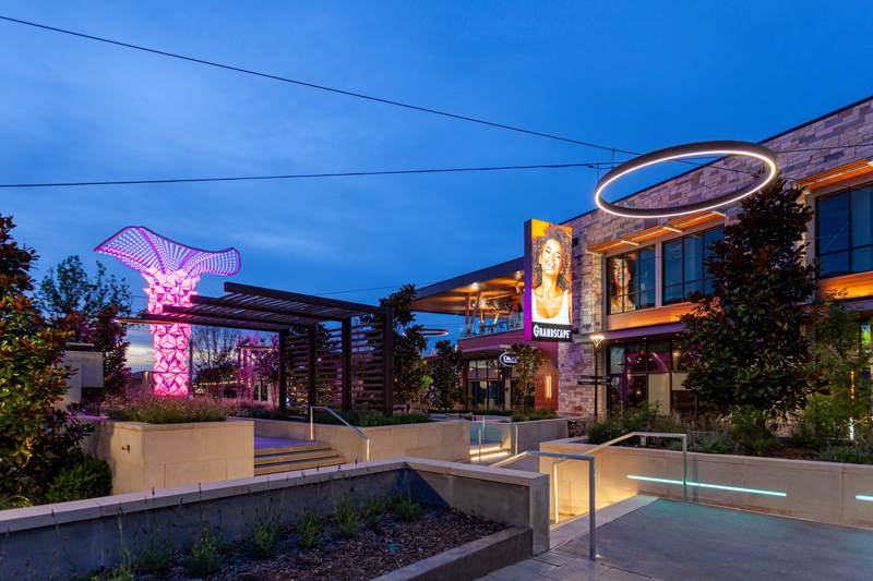 Pink and purple LED lighting illuminating an outdoor space at dusk
