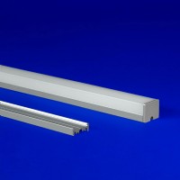 LED aluminum extrusion with a distinct three-sided lens, ideal for grid ceiling and surface mount setups, seamlessly blending with its luminous design